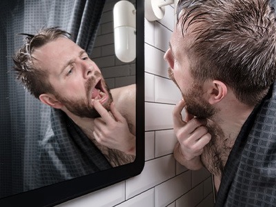 Patient in Queen Creek checking dental implants in mirror