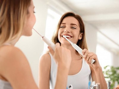 Patient brushing teeth carefully during dental implant recovery in Queen Creek