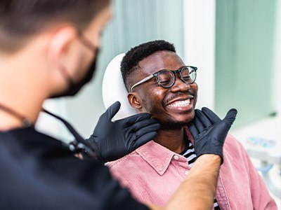 Patient in smiling confidently after dental implant restoration is complete