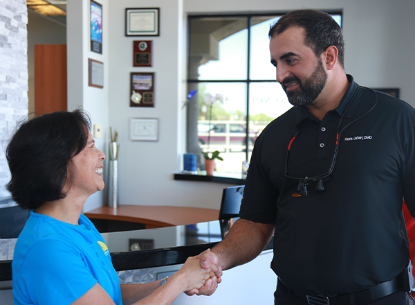 Dr. Jafari shaking hands with dental patient