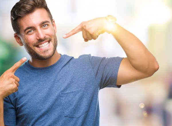 man pointing to his smile after getting dental bonding in Queen Creek 