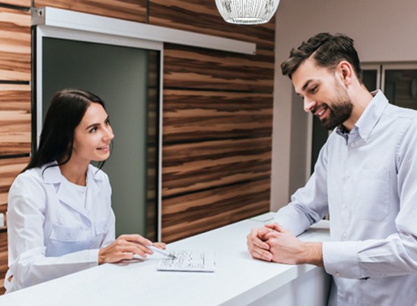 a man speaking with front desk about Cigna dental insurance