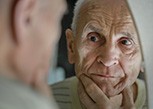 Older Queen Creek patient looking stressed in the mirror