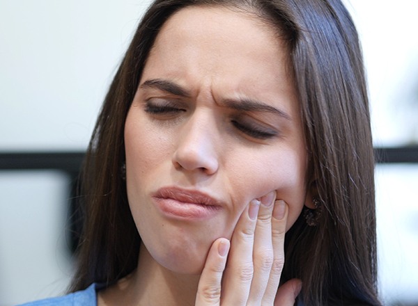 Woman holding jaw in pain