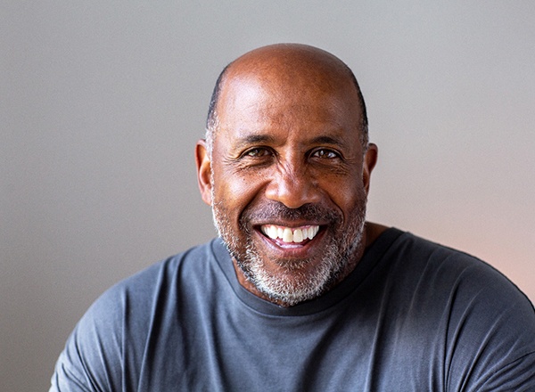 Closeup of man smiling in blue shirt