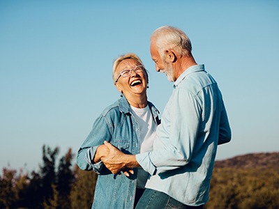 Couple smiling while hugging outside