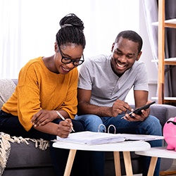 a couple sitting down together and budgeting to save up for dental implants