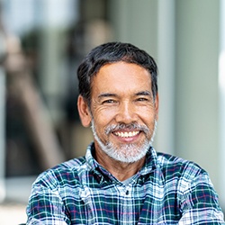 a smiling person standing with their arms crossed