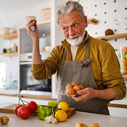 smiling person cooking dinner in a kitchen