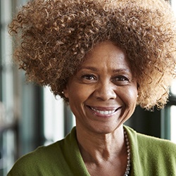 smiling person standing in front of a window