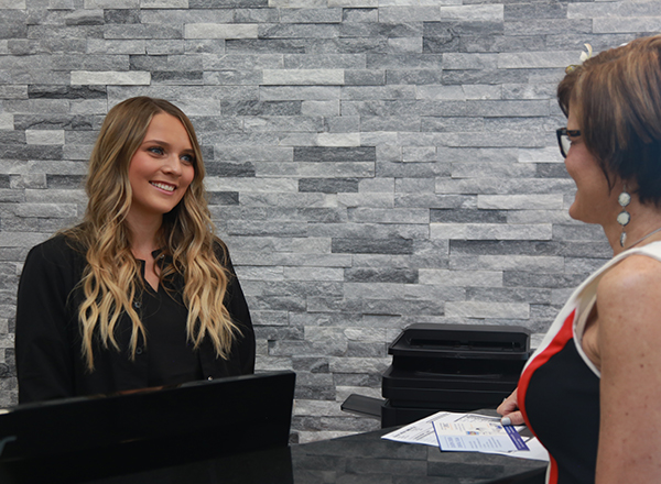 Team member greating patient at reception desk