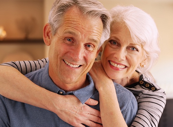 An older couple smiling and hugging.