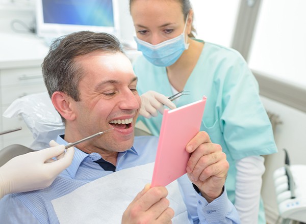 Man looking at smile in mirror