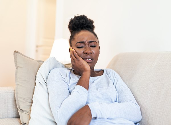 Woman struggling with toothache at home