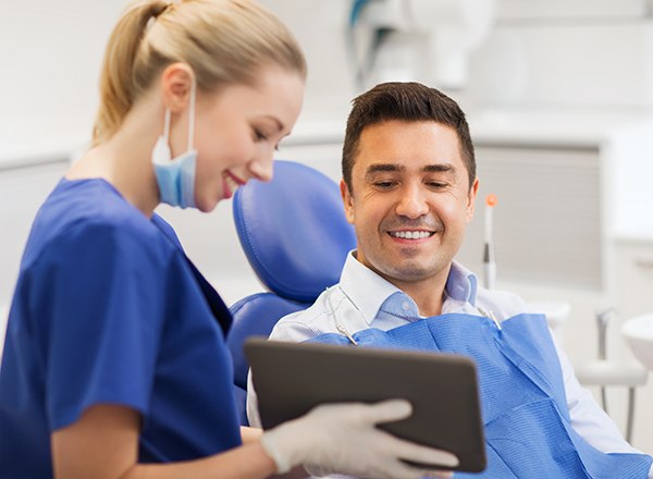 Dental assistant showing patient image on tablet