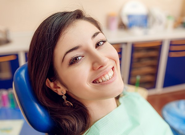 Smiling young woman in dental chair