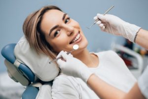 Woman smiling in the dental chair after cosmetic dentistry
