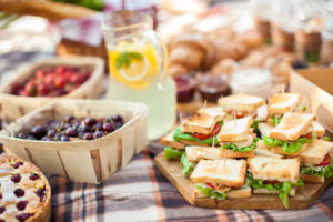 Outdoor picnic scene with food on blanket